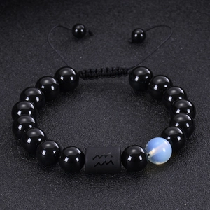 Close-up of Aquarius bead bracelet with black onyx and tiger eye stones on dark texture