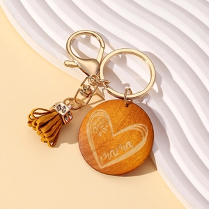 Detail of wooden mama keychain with heart engraving and yellow leather tassel
