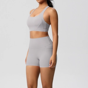 Close-up of light grey yoga set with high-waisted side pocket shorts and sports bra
