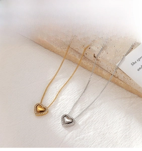 Detailed view of layered heart pendants with crystal accents in gold and silver finish