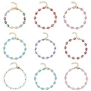 Dettaglio di nove braccialetti con perline malocchio in catene d'oro e colori assortiti