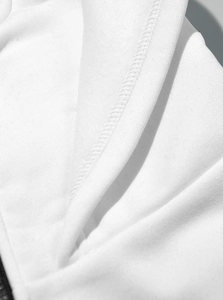Close-up of the premium white cotton fabric texture and stitching of the hooded jacket