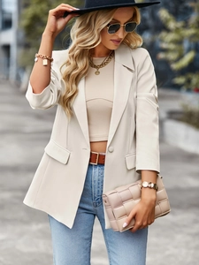 Detail of beige short sleeve blazer with flap pockets and stylish contrast stitching