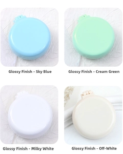 Close-up of portable folding hairbrushes in four glossy macaron colors on a white background