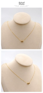 Detail of minimalist gold disc pendant with multi-ring design on delicate O-chain link