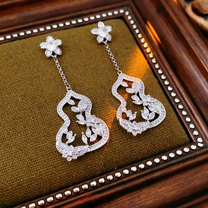 Gros plan de boucles d'oreilles en argent et zircon en forme de gourde ciselée