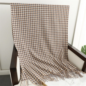 Detail of vintage plaid scarf with fringe tassels in brown and blue knit texture