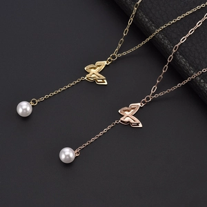 Elegant gold and rose gold butterfly pendant necklaces with pearls on black background
