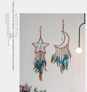 Detailed wall decor showing moon and star dreamcatchers with blue feathers and stones