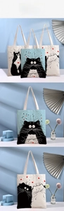 Detailed close-up of high-quality canvas tote bags with cute cartoon cat and heart prints