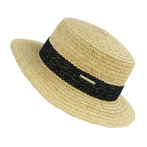 Macro shot of flat top straw hat with black lace band and golden metal logo plate