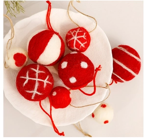 Detailed view of red and white wool felt Christmas balls with heart and snowflake patterns