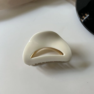 Top-down view showing internal metal spring and teeth of the cream acetate hair claw