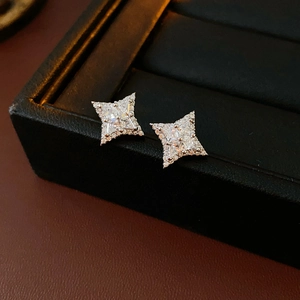 Gros plan détaillé des boucles d'oreilles étoiles en argent et zircons sur boîte noire