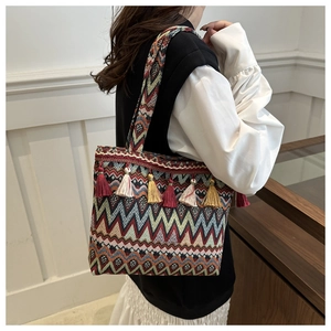 Bohemian knitted tote bag with colorful geometric stripes and fringe tassel detail