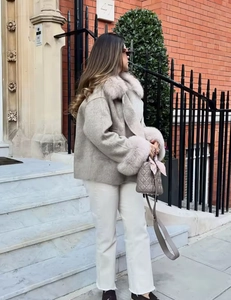 Détail du manteau en laine beige clair avec col en fausse fourrure et poignets assortis