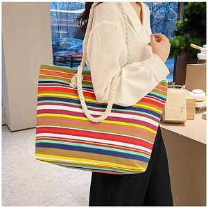Detail of colorful striped canvas tote bag with thick white cotton rope handles