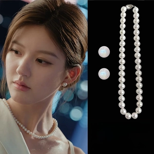 Elegant pearl jewelry set with a glossy white pearl necklace and matching stud earrings
