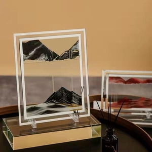 Detailed close-up of mountain-like black and gold sand patterns in a silver frame