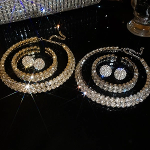 Macro view of gold and silver double-layered diamond jewelry sets on reflective surface