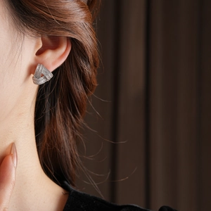 Vue latérale macro de boucles d'oreilles nœud en argent avec zircons sur un mannequin