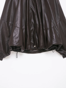 Dettaglio del bomber in ecopelle marrone scuro con coulisse regolabile e bottone in argento