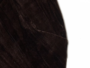 Detailed close-up of velvet dress fabric showing pocket opening and vertical stitching