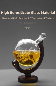 Detailed view of globe decanter with glass sailboat inside and mahogany wood stand