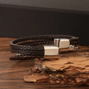 Close-up of multi-layer brown braided leather bracelet with silver-tone metal T-bar clasp