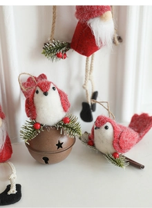 Detail of wool felt Christmas bird and vintage bronze bell with star cutouts and pine