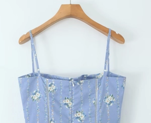 Dettaglio dell'abito floreale blu con spalline regolabili e trama a margherita elegante
