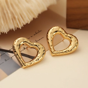 18K gold plated hollow heart studs with hammered texture on a vintage paper background