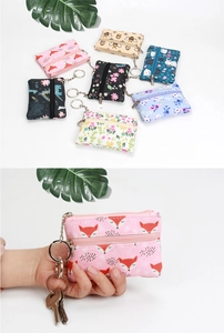 Detailed view of mini floral canvas coin purse featuring smooth zipper and metal keyring