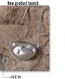 Detailed close-up of mirror-polished irregular molten pendant on a sleek snake chain