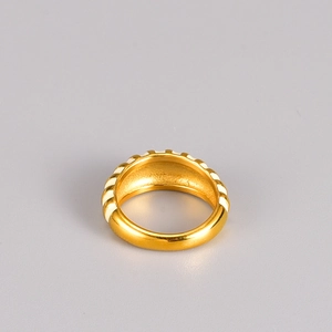 Detail view of vintage 18K gold plated ring with white enamel stripes and totem pattern