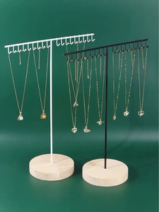 Macro view of iron necklace display stand with metal hooks and round wooden base