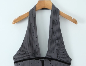 Detail of grey polka dot halter neck dress with pleated texture and velvet trim