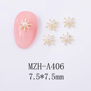 Macro view of 7.5mm gold starburst nail art charm with a central white pearl inlay