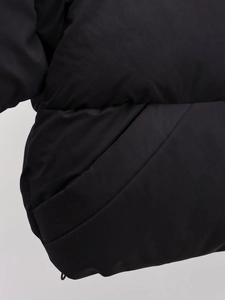 Detailansicht der Nähte und der schrägen Tasche an der schwarzen Steppjacke