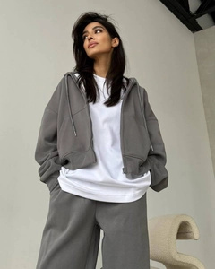 Détail du sweat à capuche zippé gris foncé et du pantalon large en tissu de coton doux