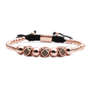 Dettaglio del bracciale intrecciato oro rosa con zirconi verdi e numeri romani incisi