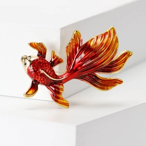 Detailed view of goldfish brooch featuring red and gold enamel craftsmanship
