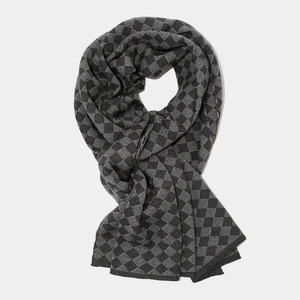 Detail of dark grey and black knitted scarf with 3D diamond pattern for winter warmth