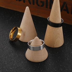 Detailed shot of 6mm brushed gold silver and black titanium steel rings on wood stands