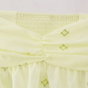 Haut court froncé jaune avec ourlet à volants et broderie en losanges verts