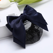 Close-up of a navy blue satin bow hair clip with a fine mesh snood net for bun styling