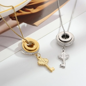 Detail shot of vintage gold and silver key pendants with crystals on ceramic plate
