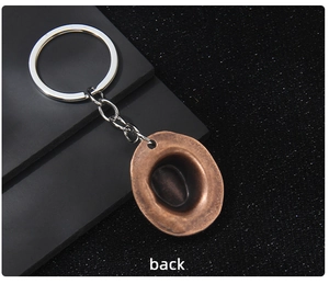 Detail view of back side of bronze cowboy hat pendant with silver metal keychain
