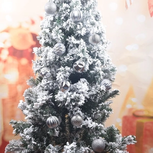 Close-up of silver Christmas balls with matte and glossy textures on a snowy tree