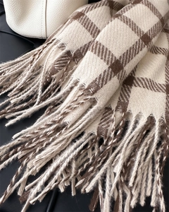 Close-up of beige and brown plaid scarf showing soft faux cashmere texture and tassels
